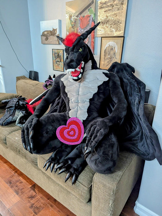 Human size plush Dragon sitting on a couch